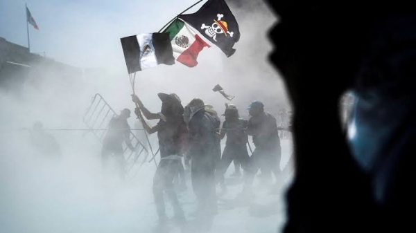 Demonstrators carry a Mexican flag, a black and white version of a Mexican flag and a One Piece flag as riot control agents are sprayed on them during a protest against insecurity and corruption in the country, on Mexico City, Mexico, November 15, 2025. Demonstrators carry a Mexican flag, a black and white version of a Mexican flag and a One Piece flag as riot control agents are sprayed on them during a protest against insecurity and corruption in the country, on Mexico City, Mexico, November 15, 2025.