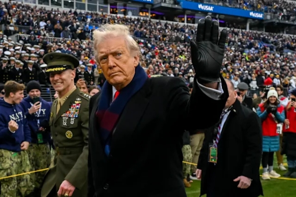 Donald J. Trump, President of the United States of America, waves while leaving the field before the game between the Navy Midshipmen and the Army West Point Black Knights at M&T Bank Stadium. Donald J. Trump, President of the United States of America, waves while leaving the field before the game between the Navy Midshipmen and the Army West Point Black Knights at M&T Bank Stadium.