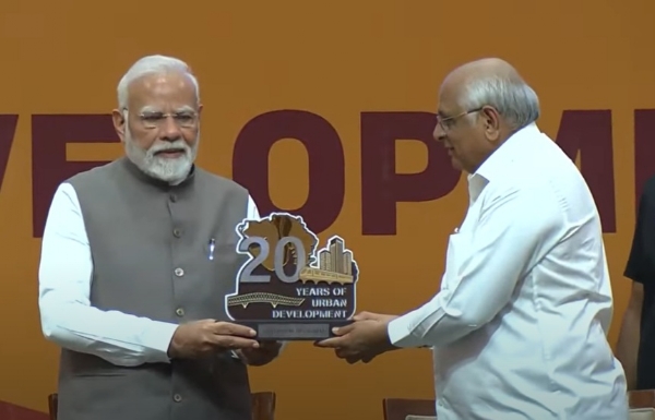 During a program organized on the 20th anniversary of the Urban Development Scheme in Gandhinagar, Chief Minister Bhupendra Patel presents a memento to Prime Minister Narendra Modi.