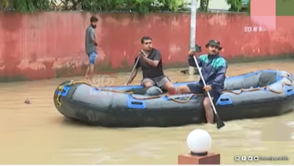 दो दिनों से हो रही मुसलाधार बारिश के बाद गुवाहाटी में जल जमाव के कारण सड़क पर चल रहे नाव की तस्वीर।