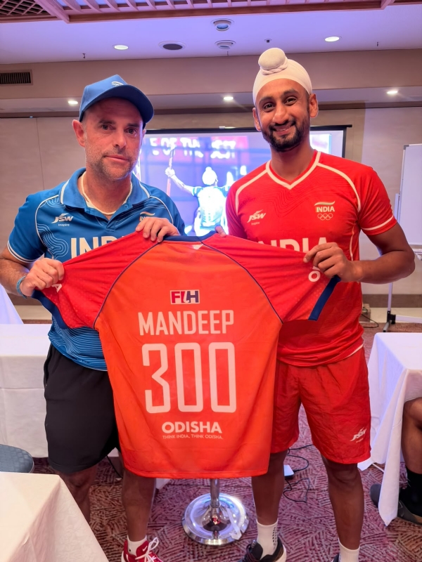India head coach Craig Fulton presents Mandeep Singh with a special commemorative jersey. Photo: Hockey India