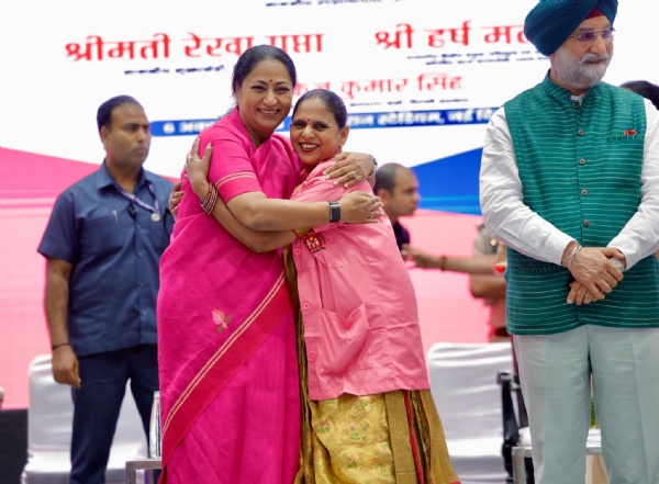 Delhi Lieutenant Governor Taranjit Singh Sandhu and Chief Minister Rekha Gupta with ASHA workers during the ASHA Sammelan at Thyagraj Stadium in New Delhi.