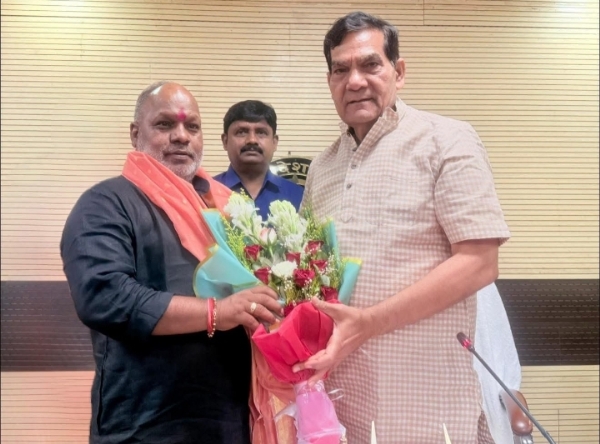 A.K. Sharma greeted with bouquet of flowers by State Minister Hansraj Vishwakarma