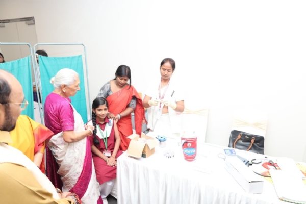 Governor Anandiben Patel encouraging girls by giving them certificates after vaccination