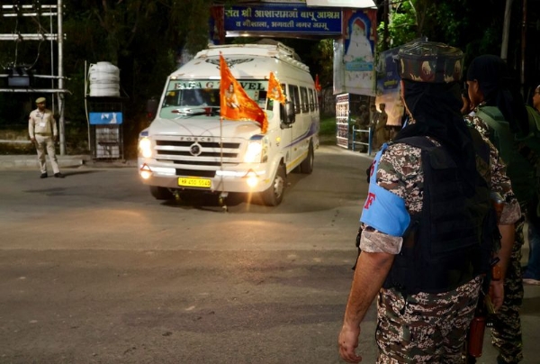 Security personnel stand guard as the second batch of pilgrims departs for the annual Shri Amarnath Ji Yatra