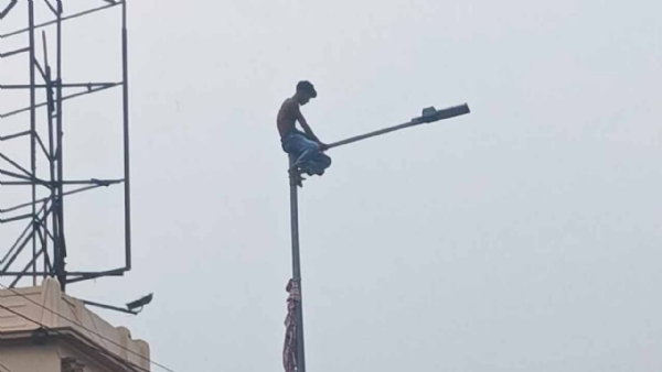 Man Climbs Lamp Post on Tala Bridge
