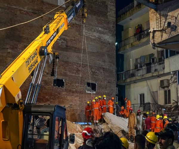 Rescue personnel work to clear the debris following the collapse of a building in Delhi’s Satya Niketan.